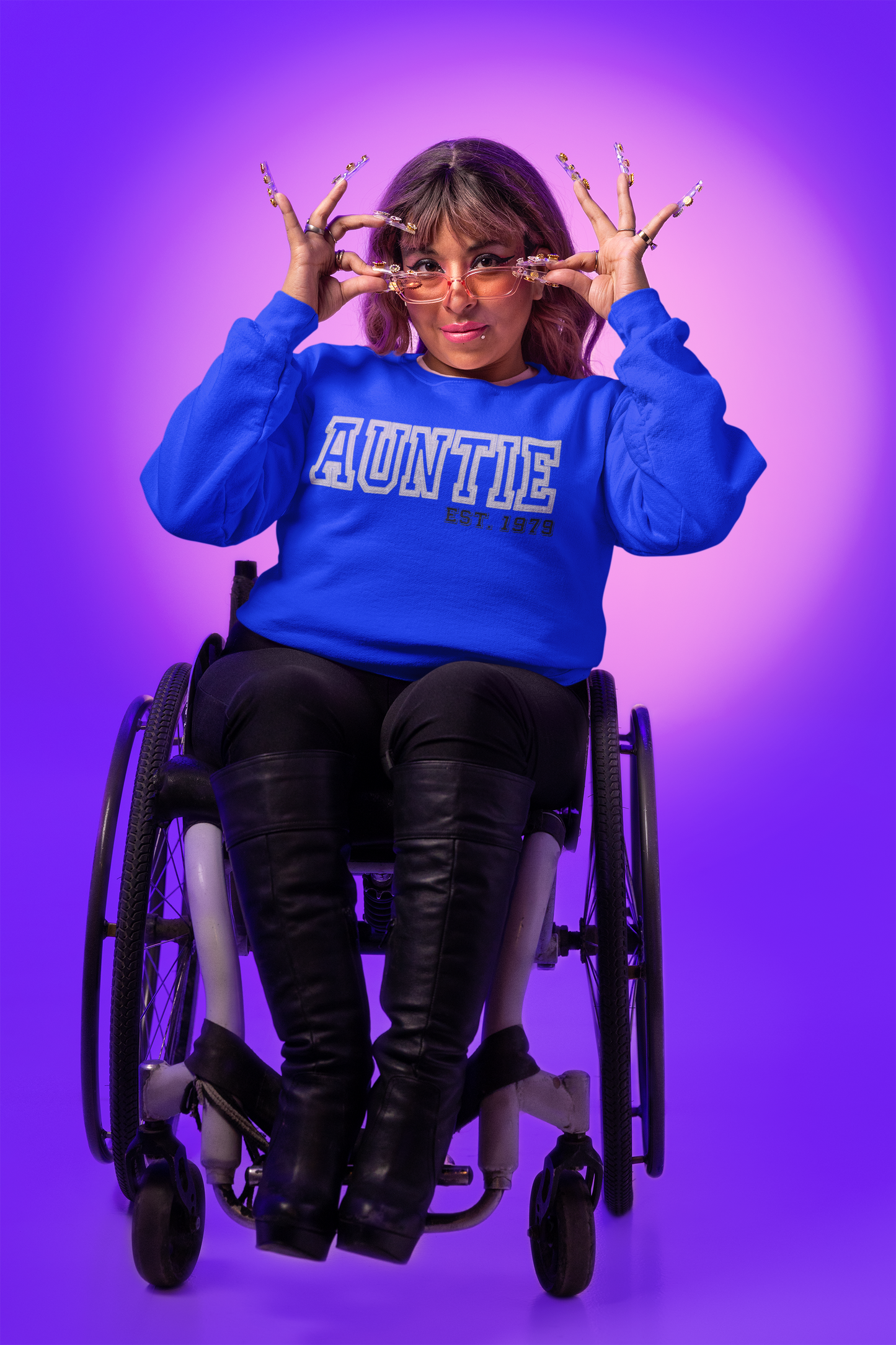A lady in a wheel chair with a blue sweatshirt that reads "Auntie est 1979"
