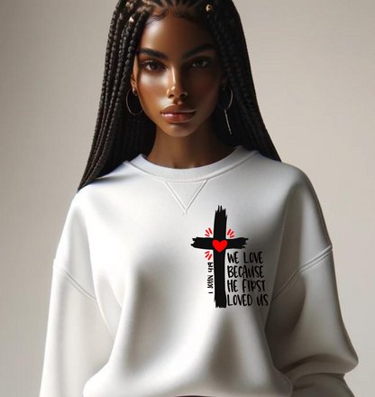 African American Woman with White sweat shirt. Black Cross with the words We Love because he first Loved