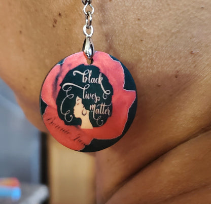 1/2 Inch Custom Earring. Pictured is  Black earring with a Woman with a large beautiful afro with the words "Black Lives Matter" inside.