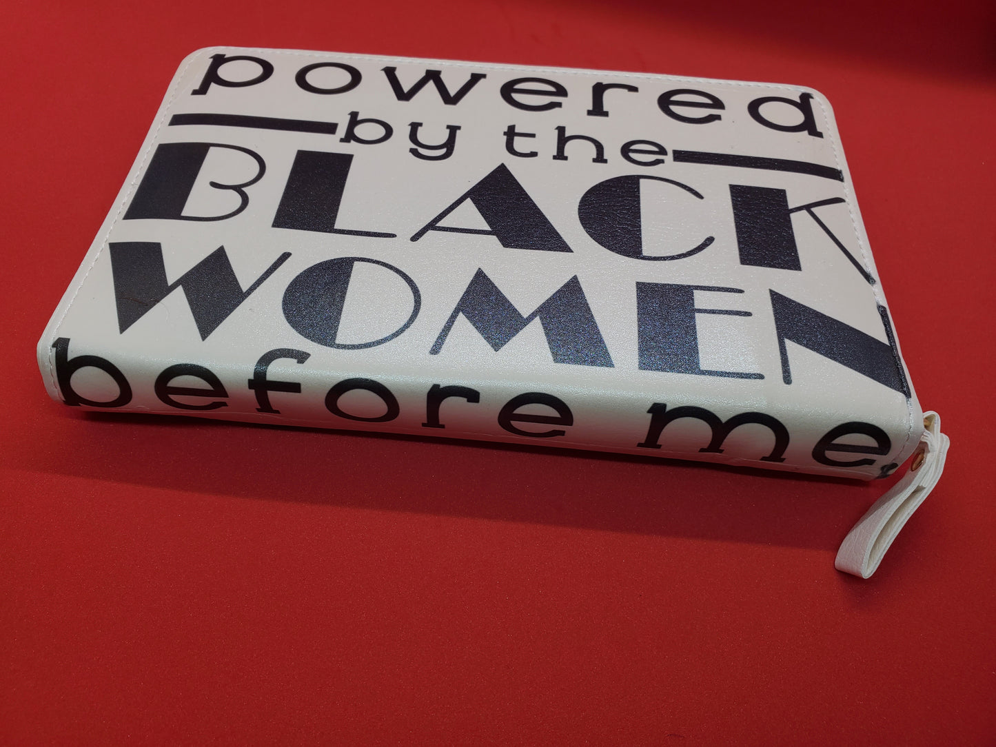 A White Leatherette Journal with the words "Powered by the Black Women before me."