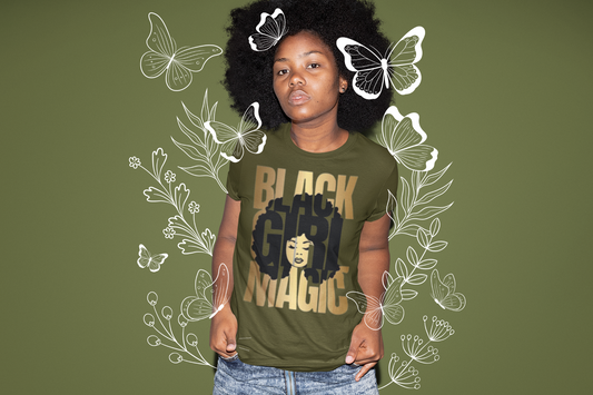 Young girl with a Green shirt with Black Girl Magic on the front and picture of a Girl embedded in the words in Black.
